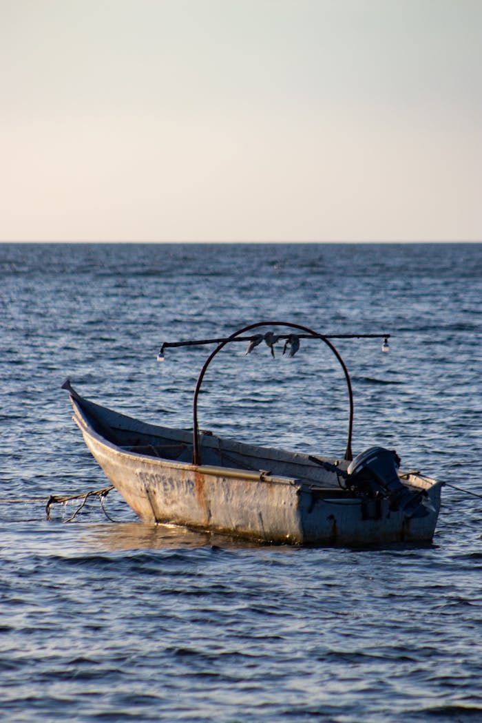 Rusty fishing boat at sea in Urb Don Jaca, Magdalena. Serene summer day.