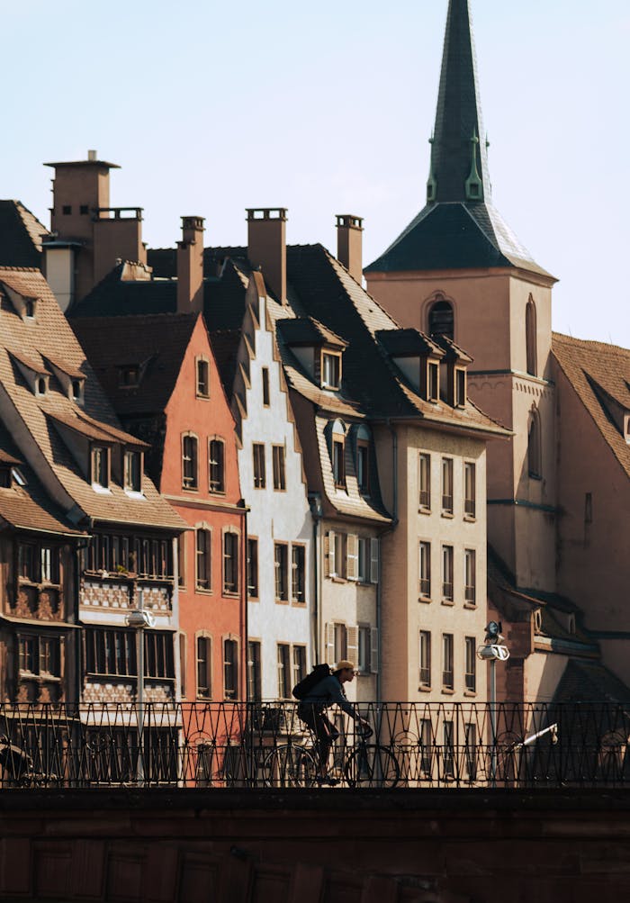 A cyclist rides through the scenic streets of Strasbourg's Old Town, showcasing beautiful historic architecture.