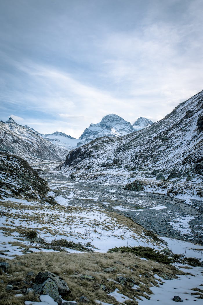 Striking view of snow-capped mountains and a frozen river in a winter wilderness setting.