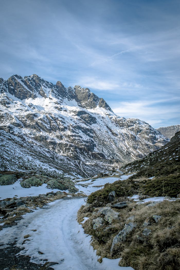 A breathtaking view of snow-covered peaks and rocky terrain under a vivid blue sky.