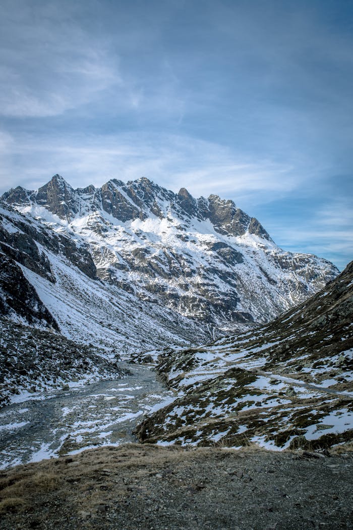 Stunning view of snow-covered mountains and valley under a clear blue sky in winter.